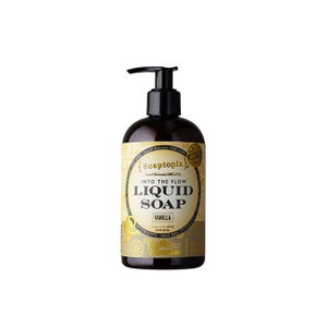 May include: A brown liquid soap bottle with a black pump dispenser. The label reads "Soaptopia" and "Into the Flow Liquid Soap Vanilla". The bottle has a gold and cream colored label with decorative floral elements.