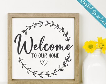 Puede incluir: Una descarga digital de un letrero de bienvenida con una corona de hojas y el texto "Bienvenido a nuestro hogar" con un corazón en el centro.
