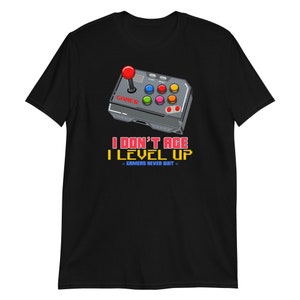 May include: Black t-shirt with a retro video game controller graphic and the text "I don't age I level up - Gamers never quit".