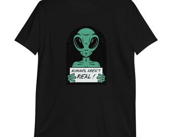 May include: Black t-shirt with a green alien holding a sign that says "HUMANS AREN'T REAL!"