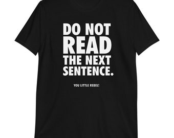 May include: Black t-shirt with white text that reads "DO NOT READ THE NEXT SENTENCE." Below the text is the phrase "YOU LITTLE REBEL!" The shirt is a short-sleeved crew neck.