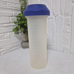 May include: A tall, cylindrical water bottle with a blue screw-on lid. The bottle is made of a translucent, off-white plastic. The lid is a darker blue and has a ridged texture for easy gripping. The bottle is empty and ready to be filled.