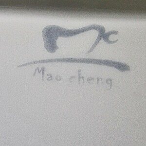 Puede incluir: Primer plano de una superficie blanca con un dise&ntilde;o gris estilizado y el texto "Mao cheng" en una fuente manuscrita. El dise&ntilde;o es un s&iacute;mbolo abstracto.