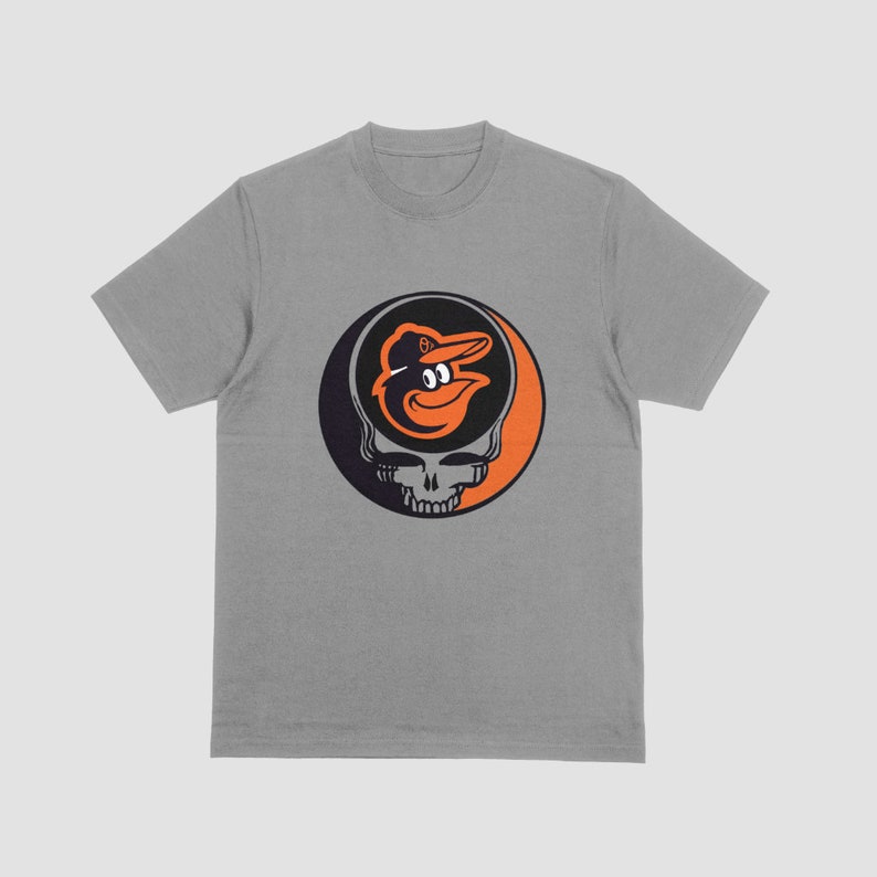 May include: A gray t-shirt with a black and orange graphic of a baseball mascot's head inside a smiling skull.