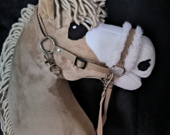 May include: A plush brown and white horse head with a beige bridle and a long white mane. The horse head is a toy for children.