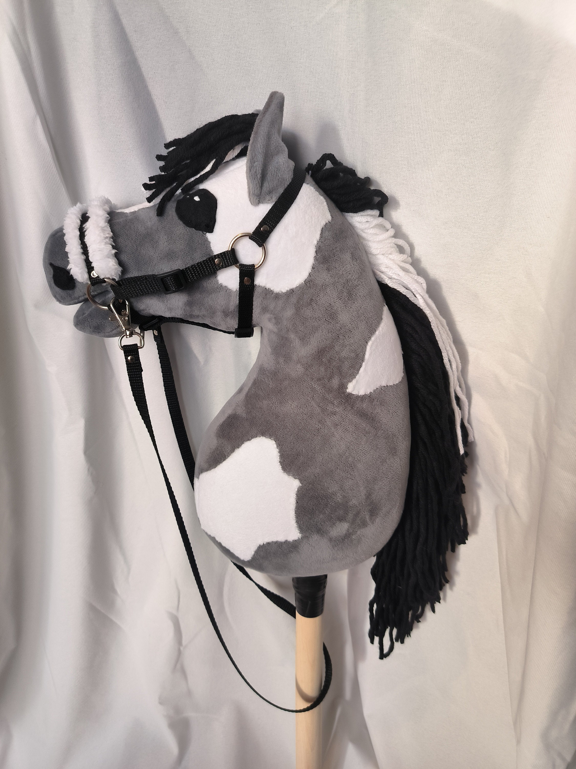 Gray hobby horse with white patches, reins and halter included.