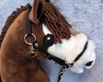 Può includere: Testa di cavallo a dondolo in peluche marrone con briglia e redini nere. Il cavallo ha un muso bianco, occhi neri e una criniera marrone. Le orecchie sono marroni e dritte.