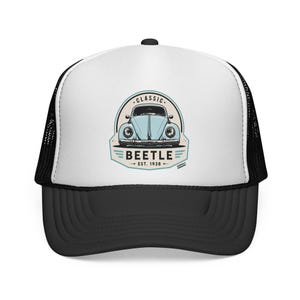 Pode incluir: Um boné trucker branco e preto com uma estampa gráfica de um carro clássico azul claro. O design inclui o texto CLASSIC BEETLE EST. 1938 num emblema circular. O boné tem um painel frontal branco, uma aba preta e uma rede preta na parte traseira.