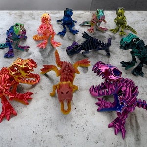 Op de afbeelding: Een verzameling van 10 kleurrijke dinosaurus skeletfiguren. De dinosaurussen zijn gemaakt van plastic en hebben een metallic afwerking. De kleuren omvatten rood, oranje, geel, groen, blauw, paars en zwart.