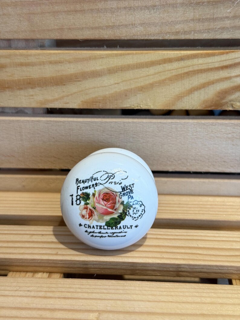 Puede incluir: Pomo de cer&aacute;mica blanco con un dise&ntilde;o floral y el texto "Beautiful Flowers: Paris West Grove PA 18... Chatellereault"
