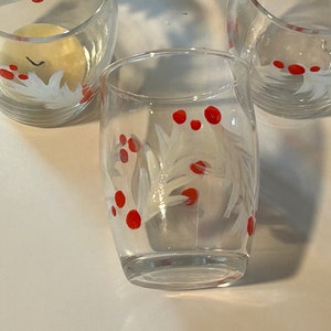 May include: Three clear glass cups with white painted holly leaves and red berries. The cups are perfect for holiday entertaining.