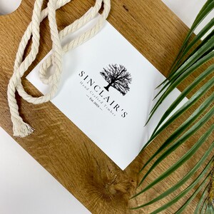 May include: A white card with black text and a tree graphic. The text reads "Sinclair's Hand Crafted Timber - Est. 2021 - "
