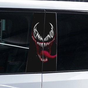 Puede incluir: Un coche negro con un gráfico de Venom en las ventanas traseras. El gráfico es una ilustración en blanco y negro de la cara de Venom con la palabra "Venom" escrita en letras blancas.