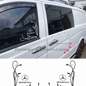 May include: A white van with a black and white decal on the side window. The decal features a stylised floral design with a Mercedes-Benz logo and the word "SPRINTER".