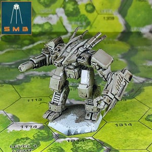 May include: A detailed, gray miniature robot with articulated limbs and weaponry, standing on a hexagonal base. The robot is positioned on a green and tan game board. The image includes the logo "SMB" in a blue square.