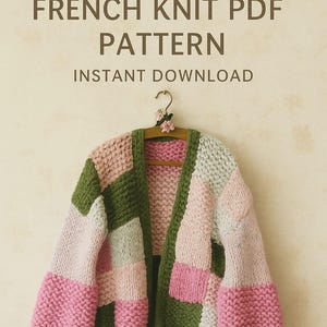 Könnte beinhalten: Ein grob gestrickter Cardigan im Patchwork-Design mit Blöcken in Rosa, Grün und Grau. Das Kleidungsstück hängt an einem Holzkleiderbügel, der mit einer kleinen floralen Verzierung versehen ist. Der Text oben lautet "Patron en Français" und "FRENCH KNIT PDF PATTERN INSTANT DOWNLOAD."