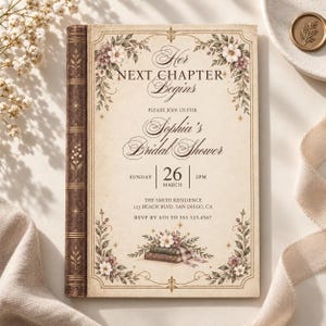 May include: A rectangular bridal shower invitation designed to resemble an antique book with a brown spine. The cream-colored card features floral illustrations, gold star accents, and text reading Her NEXT CHAPTER Begins, Sophia's Bridal Shower.