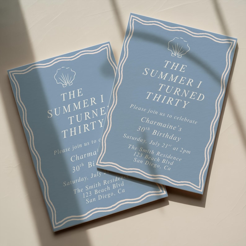 May include: Two light blue birthday invitations with white text and a seashell graphic. The text reads "The Summer I Turned Thirty" and includes event details. The invitations are rectangular with a decorative border.