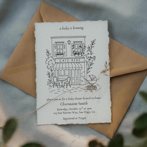 May include: Baby shower invitation with a hand-drawn illustration of a cafe, a stroller, and the text "a baby is brewing." The invitation is on textured paper, placed on a brown envelope, with details for the event.