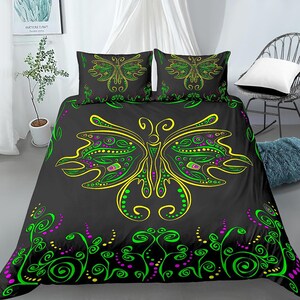 May include: Black bedding set featuring a green and yellow butterfly design. The butterfly has a detailed pattern of dots and swirls. The set includes a duvet cover and two pillowcases.