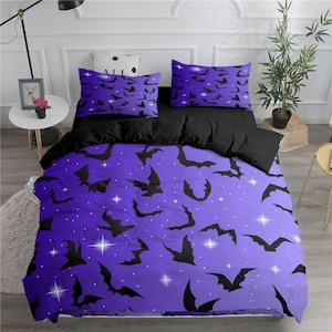 Puede incluir: Juego de cama morado y negro con un patrón de murciélagos y estrellas. La funda nórdica presenta un degradado de morado con estrellas blancas y murciélagos negros. Las fundas de almohada tienen un fondo negro con estrellas blancas y murciélagos negros.