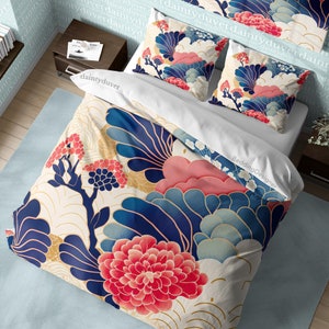 May include: A white duvet cover with a blue, pink, and gold floral pattern. The duvet cover features large, stylized flowers and leaves. The pattern is reminiscent of traditional Japanese art.