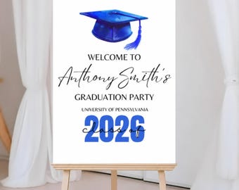 May include: A graduation party welcome sign on an easel. The sign features a blue graduation cap illustration above the words "WELCOME TO" and the name "Anthony Smith's". Below is "GRADUATION PARTY", "UNIVERSITY OF PENNSYLVANIA", and "CLASS OF 2026".