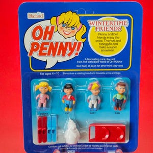 May include: A vintage "Oh Penny! Wintertime Friends" mini playset. The blue blister pack contains four small figures, skis, a toboggan, and a snowman. The packaging features the Bluebird logo and text that reads "Penny and her friends enjoy the snow."