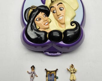Può includere: Un playset viola a tema Aladdin con un coperchio incernierato con Jasmine e Aladdin. Include figurine in miniatura di Jasmine, Aladdin e un tappeto magico. Il set è un giocattolo da collezione.
