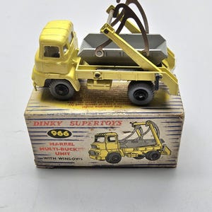 Puede incluir: Un camión de juguete Dinky Supertoys Marrel Multi-Bucket Unit vintage. El camión amarillo tiene un cubo gris y se muestra en su caja original. La caja presenta una ilustración del camión y el texto "966".
