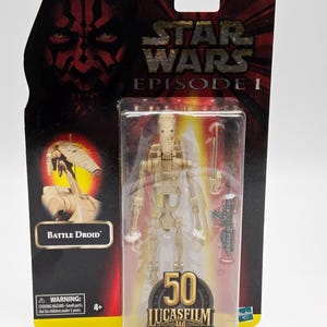 Peut inclure: Figurine Battle Droid de Star Wars Épisode I dans son emballage d'origine. La figurine est beige et est livrée avec des accessoires. L'emballage présente Dark Maul et le texte "50 Lucasfilm Ltd."