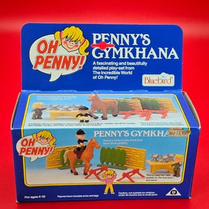 May include: A vintage "Penny's Gymkhana" playset box with a blue background and colorful illustrations. The box features the text "Oh Penny!" and images of horses, jumps, and figures. The playset is designed for ages 4-10.