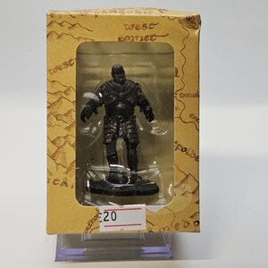 May include: A black figurine of a character from a fantasy series, displayed in a cardboard box. The box has a map design and the words "west emnet". The figurine is on a black base.