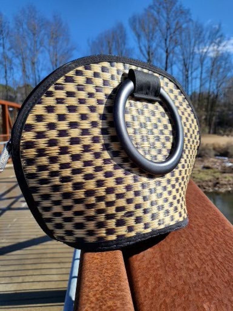 Peut inclure: Un sac &agrave; main tiss&eacute; noir et beige avec une anse en forme d'anneau noir. Le sac a un motif &agrave; carreaux.