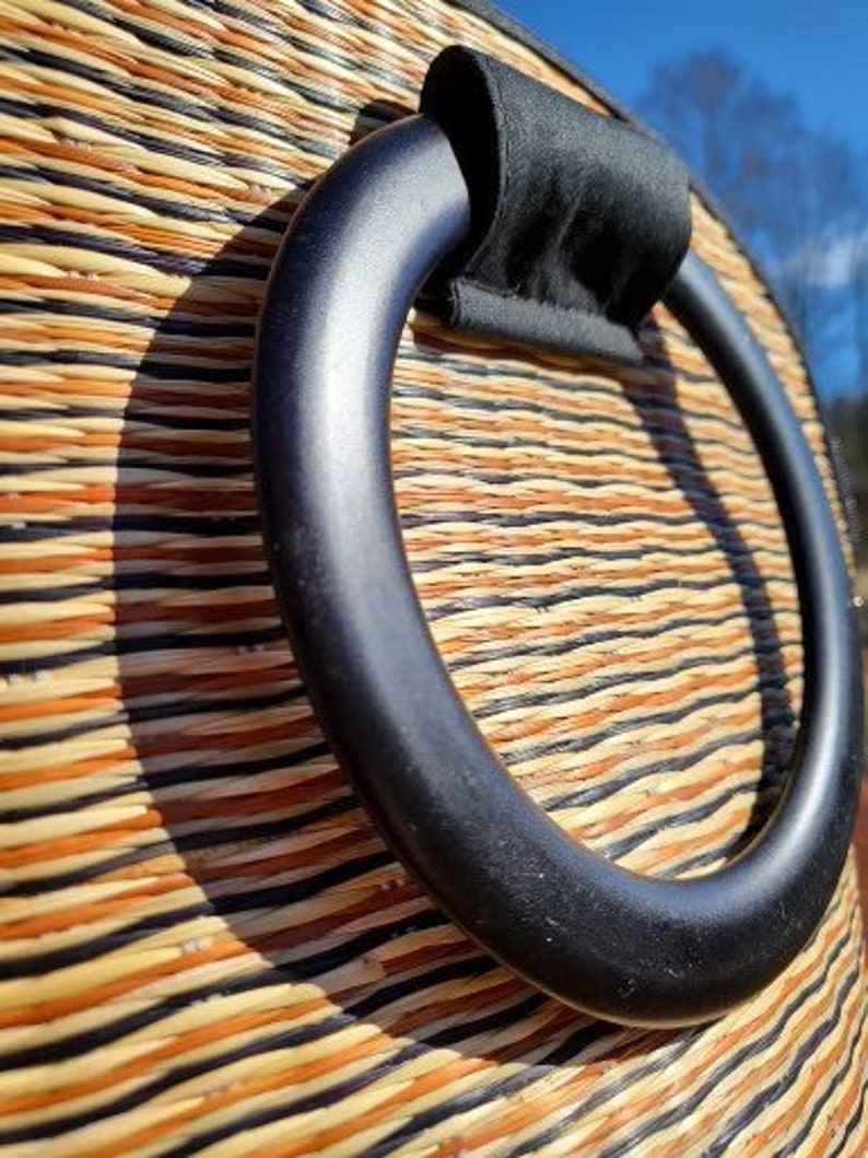Peut inclure: Gros plan sur une poign&eacute;e tiss&eacute;e noire sur un sac tiss&eacute; naturel. La poign&eacute;e est une boucle &eacute;paisse et arrondie avec une doublure en tissu noir.