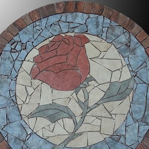 Könnte beinhalten: Ein rundes Mosaik-Kunstwerk mit einer roten Rose mit grünen Blättern, umgeben von einem blauen und weißen Mosaikrand. Der äußere Rand ist aus braunem Holz.