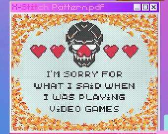 May include: A cross-stitch pattern featuring a skull with a red nose and four hearts. The text reads "I'm sorry for what I said when I was playing video games". The pattern is 150 x 120 stitches and uses 8 DMC colors.