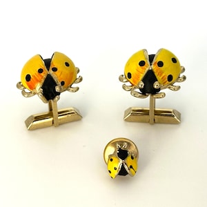 May include: A set of three gold-toned cufflinks and a tie tack featuring yellow and black enamel ladybug designs.