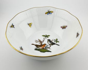 May include: A white porcelain bowl with a gold rim and a woven pattern. The bowl features a hand-painted design of birds and butterflies in shades of blue, yellow, red, and green.