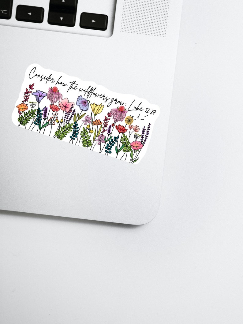 K&ouml;nnte beinhalten: Ein Aufkleber mit einer bunten Wildblumenillustration und dem Text "Consider how the wildflowers grow. Luke 12:27." Das Design zeigt verschiedene Blumen in Rosa, Lila, Gelb und Orange, mit gr&uuml;nen Bl&auml;ttern.