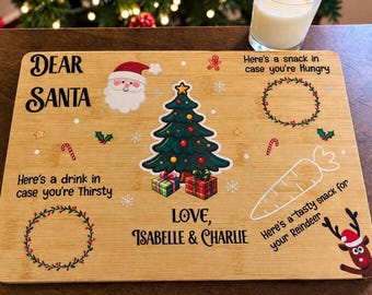 May include: A rectangular bamboo serving board featuring Christmas graphics and text. It includes a Santa face, a decorated tree with gifts, a reindeer, and text reading Dear Santa, Here's a snack in case you're hungry, Here's a drink in case you're thirsty, Love, Isabelle & Charlie, and Here's a tasty snack for your reindeer.