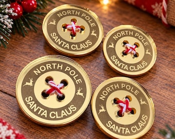 May include: Four circular gold-toned buttons featuring the engraved text NORTH POLE and SANTA CLAUS, along with small reindeer silhouettes. Each button has four holes threaded with red and white twine, creating a cross pattern in the center.