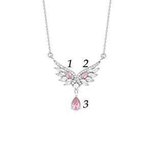 Peut inclure: Un collier argent&eacute; avec un pendentif en forme d'ailes. Les ailes sont orn&eacute;es de pierres pr&eacute;cieuses claires et roses. Une pierre pr&eacute;cieuse rose en forme de goutte pend du centre des ailes.