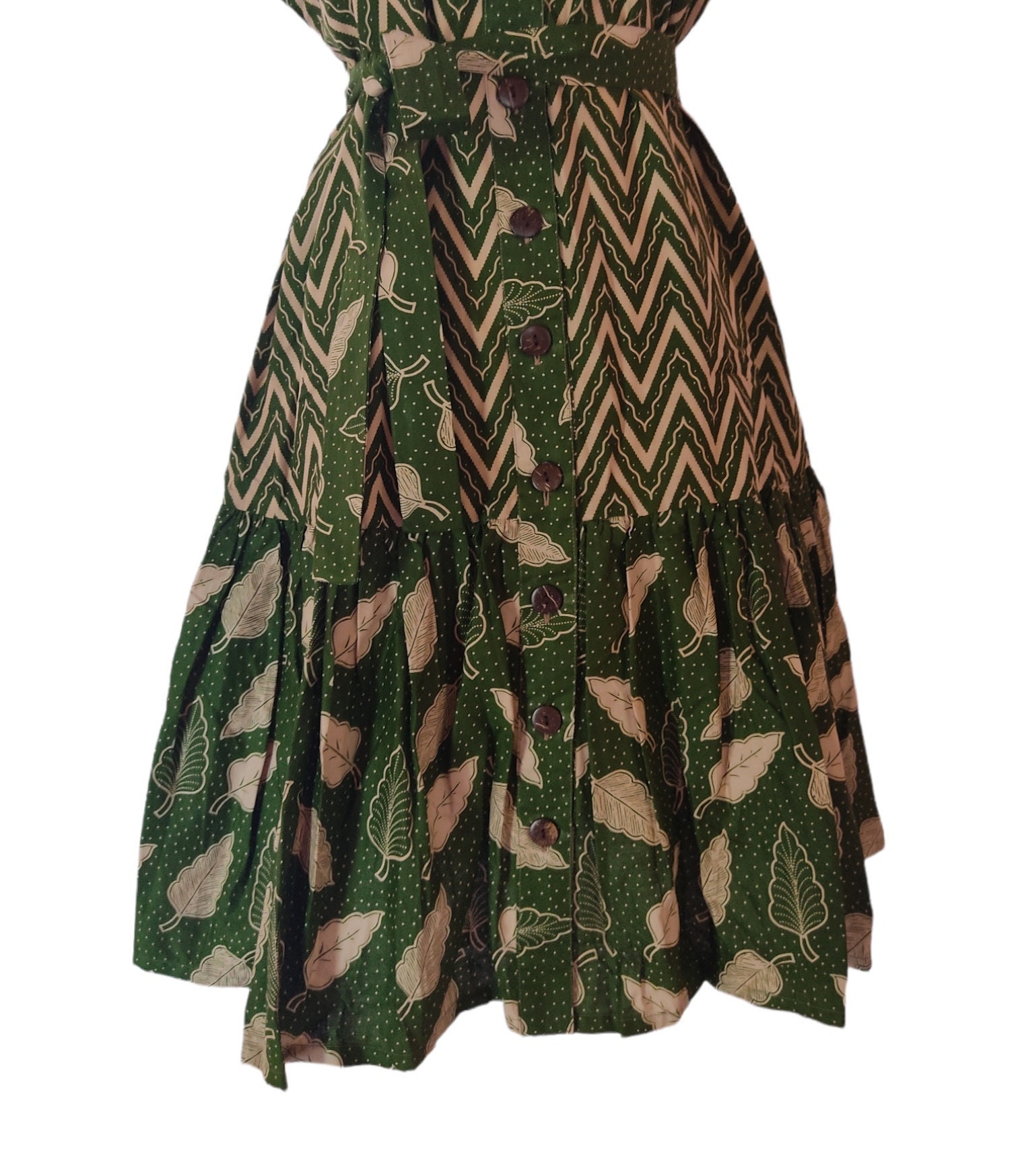 Green sleeveless batik dress for women, featuring a vibrant traditional pattern. Green sleeveless batik dress for women, featuring a vibrant traditional pattern.