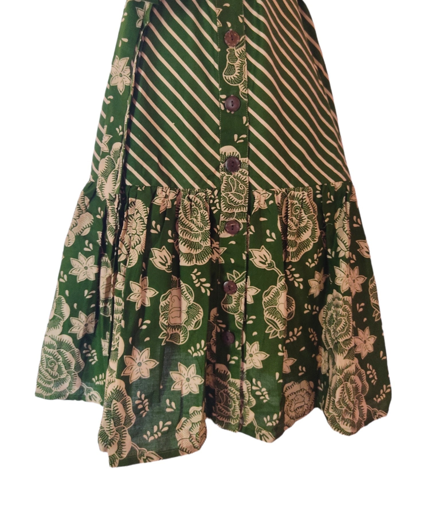 Green sleeveless batik dress for women, featuring a vibrant traditional pattern. Green sleeveless batik dress for women, featuring a vibrant traditional pattern.