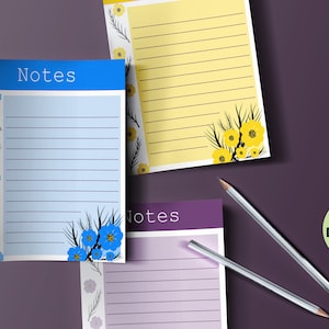 May include: A collection of lined notepads with floral designs and the word "Notes" at the top. The pads feature blue, yellow, and purple color schemes, with pencils and a "Digital Download" graphic.