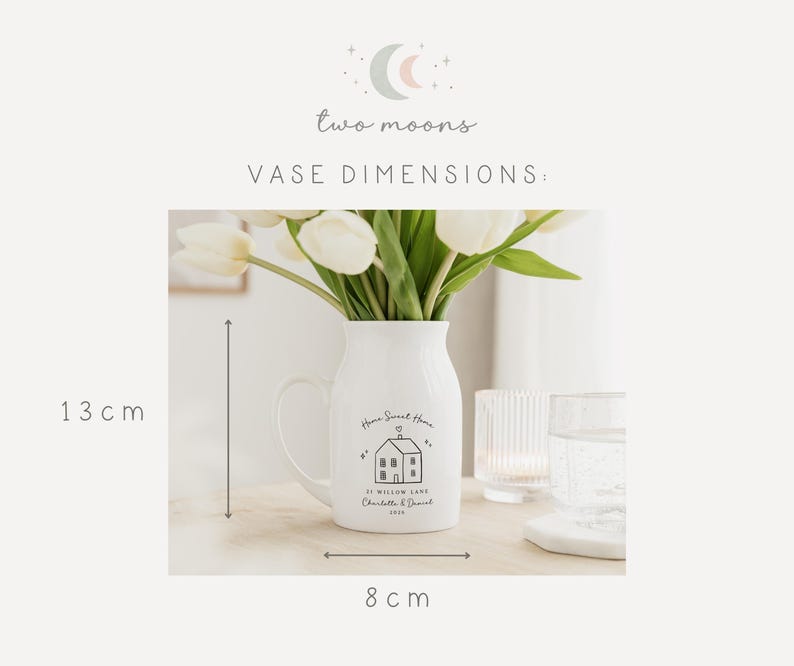 May include: White ceramic vase with a handle, holding white tulips. The vase has a house graphic and the text "Home Sweet Home". The vase is 13 cm tall and 8 cm wide.