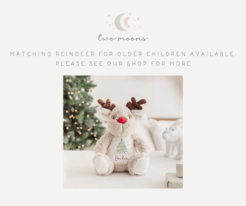 May include: A plush reindeer toy with brown antlers, a red nose, and embroidered details. The reindeer has a green Christmas tree design and the name "Emilia" embroidered on its chest. The text "two moons" is at the top.