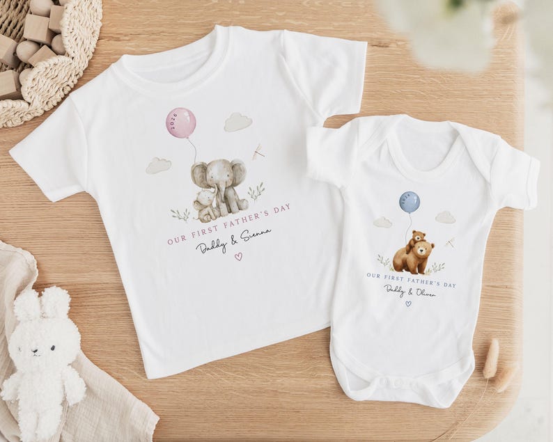 May include: White t-shirts and a onesie with watercolor illustrations. One shirt features an elephant holding a balloon, the text "OUR FIRST FATHER'S DAY Daddy & Sienna". The onesie has a bear with a balloon, text "OUR FIRST FATHER'S DAY Daddy & Oliver".