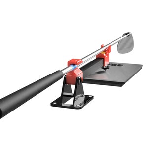 May include: A red and black golf club swing trainer with a metal base and a black grip. The club is in a raised position, ready to swing.